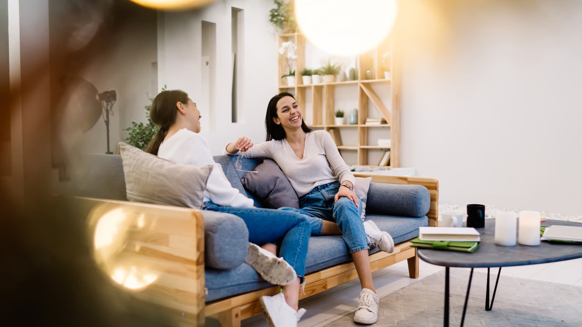 Happy friends having conversation on sofa